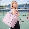 A lightweight pink tote bag is carried by a woman on a tennis court, featuring a logo and adjustable straps.