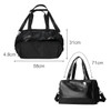 A black duffle bag with two handles, a removable shoulder strap, and a zippered opening. Features a logo.