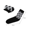 A pair of black and grey patterned socks, one rolled up, showcasing a woven design with a towel bottom.