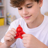 A red silicone keychain with three bubbles, held by a young person wearing a white shirt.