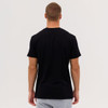 A man wearing a black Everyday Tee, viewed from the back, with grey shorts. The tee has a logo on it.