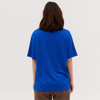 A blue tee shirt viewed from the back, featuring short sleeves and a relaxed fit. It has a logo on the back.