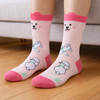 Ear-shaped crew socks with pink accents featuring a playful dog pattern on a light pink background.