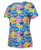 A printed scrub top featuring a vibrant design with various smiling cartoon faces in blue, pink, and yellow.