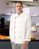 A unisex executive chef jacket in white with black trim, worn by a model in a kitchen setting.