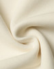 A close-up of soft, cream-coloured fabric showcasing a smooth texture and knit pattern.