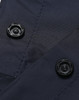 Close-up of navy nylon fabric featuring black buttons, part of waterproof rain pants.