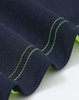 A close-up of a navy polo shirt with bright green stitching and detailing along the edges. It features a logo.