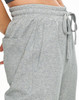 A pair of grey unisex sweatpants with side pockets and an elastic waistband. Features a brand logo.