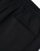Black unisex sweatpants with an elastic waistband and a patch pocket on the side. Features a logo.