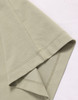A close-up of a light green premium cotton T-shirt featuring short sleeves and neat stitching.