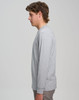 A grey long-sleeve T-shirt displayed on a model from the side, featuring a simple design and a logo.