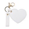 A heart-shaped compact mirror in white with a keychain and a gold-coloured clasp. It features a simple design.