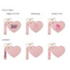 A heart-shaped compact mirror in pink with a keychain attachment, featuring various print designs.