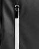 A close-up of a black backpack featuring a zippered compartment with a contrasting white zipper.