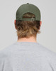 A cotton twill unstructured cap in olive green, viewed from the back, worn by a person with medium-length hair.
