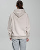 An oversized unisex hoodie in a light beige colour, featuring a spacious hood, shown from the back.