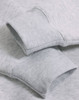 Close-up of a light grey fleece oversized hoodie featuring ribbed cuffs and a soft texture.