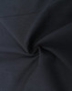 A close-up of a black cotton blend fabric showing its texture and smoothness, featuring a subtle swirl pattern.