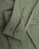 A green cotton blend long-sleeve shirt featuring buttoned cuffs and a logo.