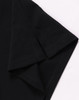 A black ultrafine cotton pique polo featuring a folded sleeve, with a small logo on the fabric.