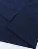 A close-up of a navy blue polo shirt displaying its fabric and hem details. The shirt has a logo.