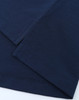 A close-up of navy blue fabric featuring stitched hems, showcasing the texture and quality of a polo shirt.