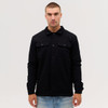 A black Studio Canvas Jacket features a collared design and front pockets, worn by a model against a plain background.
