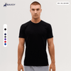 A plain black T-shirt displayed on a model, featuring a logo and available in various sizes.