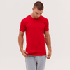 A red T-shirt is displayed on a model wearing grey shorts, with a neutral background. The shirt has no visible branding.