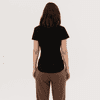 A black women's essential tee is displayed, featuring a simple design and a fitted silhouette from the back.