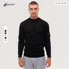 A crew sweatshirt in black, featuring long sleeves and a round neckline. The model is standing against a neutral background.