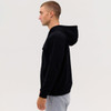 A black zip hood featuring a hood and a sleek design, displayed on a model from the side.