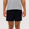 A pair of black running shorts, displayed on a person wearing a grey t-shirt, with a logo on the shorts.