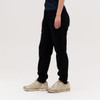 Black track pants featured alongside a person wearing gold sneakers, with a simple, neutral background.