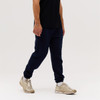 Navy blue track pants with elastic cuffs, paired with a black shirt and light-coloured sneakers.