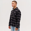 A long sleeve flannel shirt in black and grey check pattern, featuring a pocket and a logo.