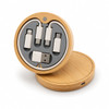 A circular wireless charger set in bamboo, featuring various charging connectors and a USB port inside.