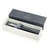 A metal ballpoint pen in matte black, presented in a stylish box with a logoed lid and grey cushioning.