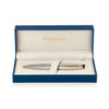 A brushed stainless steel ballpoint pen with gold accents, presented in a blue box with a soft interior.