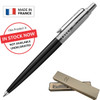 A metal ballpoint pen in black with a silver clip, presented in a tan box, featuring a logo.