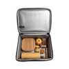 A cooler bag containing a drink bottle, lunch box, apple, and snacks, with a silver interior and a branding logo.