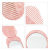 A portable acetate hair comb in pink with a mirror, featuring a marbled design and a logo.
