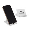 A white phone stand with a smartphone propped up, featuring a logo on one side.