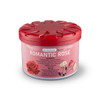 A round container of air freshener with a pink label featuring red and white roses and a red lid.