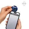 A hand holds a blue NFC acrylic fridge magnet near a smartphone, which displays a notification.