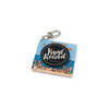 A keychain with a circular black disc labelled "Vinyl Record" attached to an acrylic square featuring a beach scene.