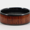 A ceramic ring featuring a black exterior and a wooden-textured centre, showcasing rich brown hues.