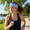 A woman jogs along a path wearing a blue and pink patterned polyester spandex sport headband.
