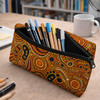 A small neoprene pencil pouch in vibrant orange and black, filled with various pens and markers, sits on a desk.